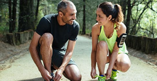 Two runners tying their shoes